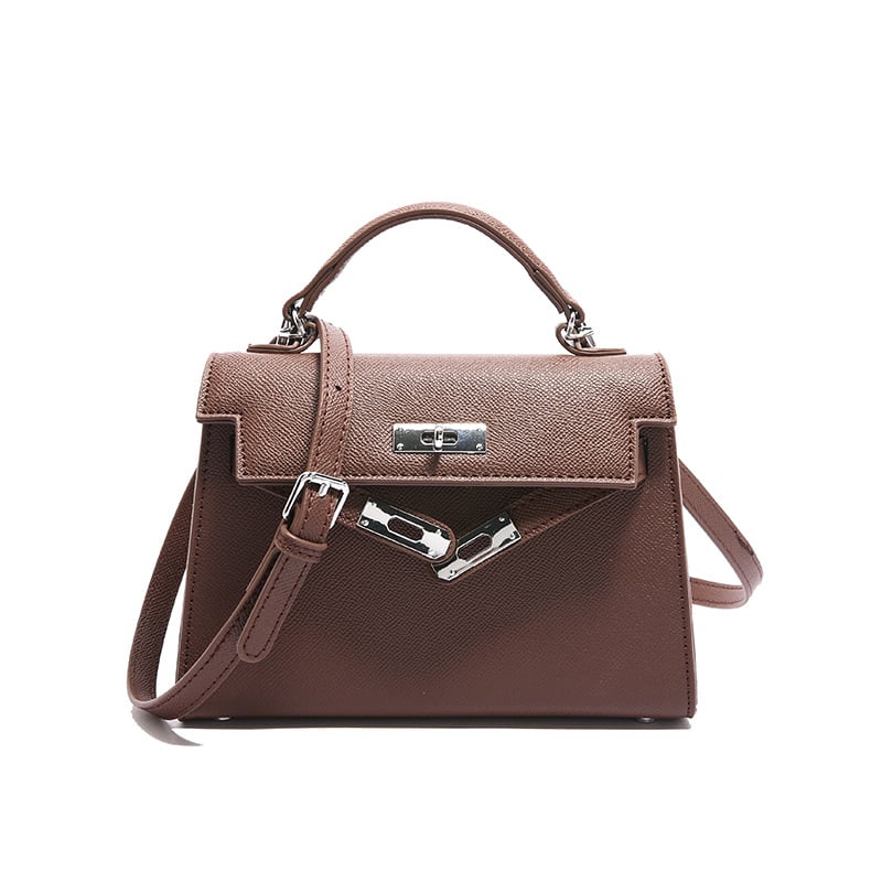 A woman carrying a small square bag with a lock