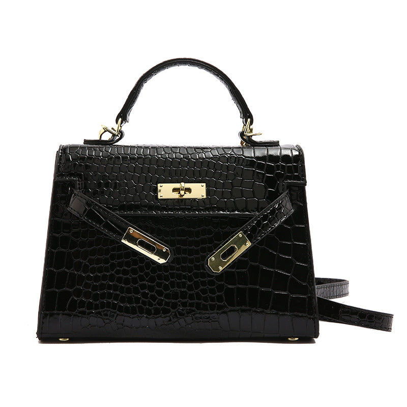 A woman carrying a small square bag with a lock