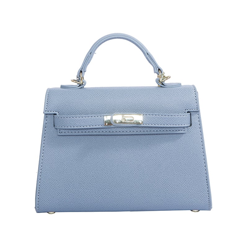 A woman carrying a small square bag with a lock