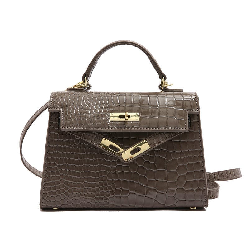 A woman carrying a small square bag with a lock